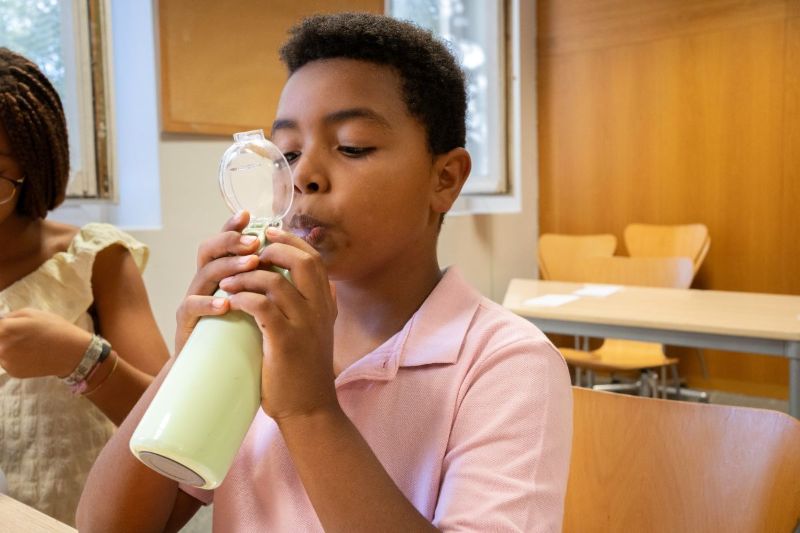 Kid drinking water at his desk